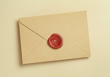 Bej arka planda balmumu mühürü olan güzel bir davetiye zarfı, üst görünüm