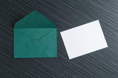 Boş davetiye kartı ve zarf siyah desenli masa üzerinde, düz yatıyordu. Tasarım için boşluk