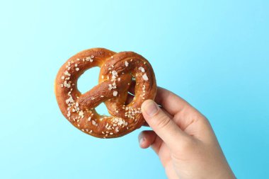 Açık mavi arka planda lezzetli krakerli kadın, yakın plan.