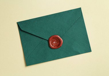 Bej arka planda balmumu mühürü olan güzel bir davetiye zarfı, üst görünüm