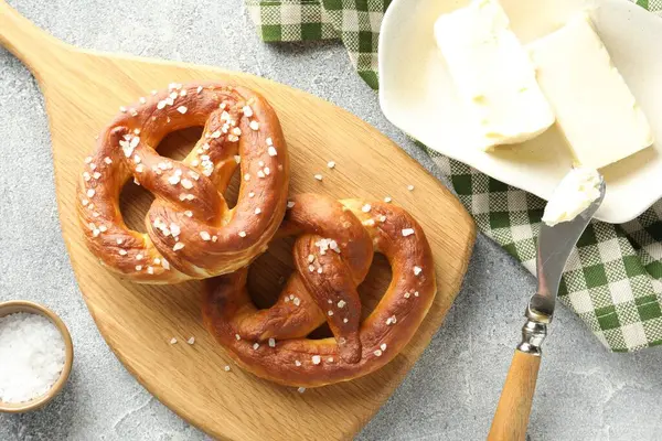 Tuz ve tereyağlı lezzetli krakerler açık gri masada, düz yerde.