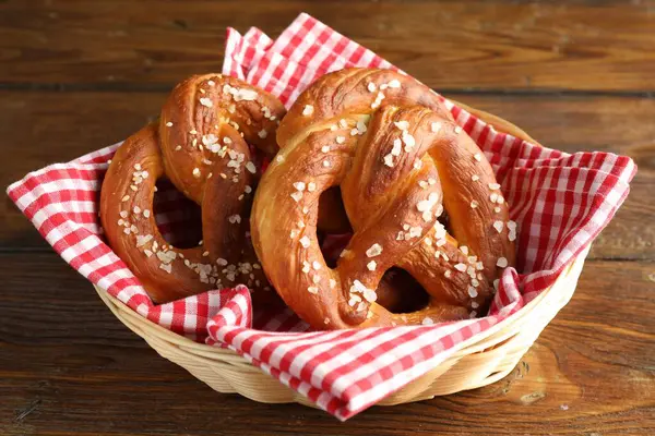 Hasır sepetteki tuzlu krakerler ahşap masada, yakın plan.