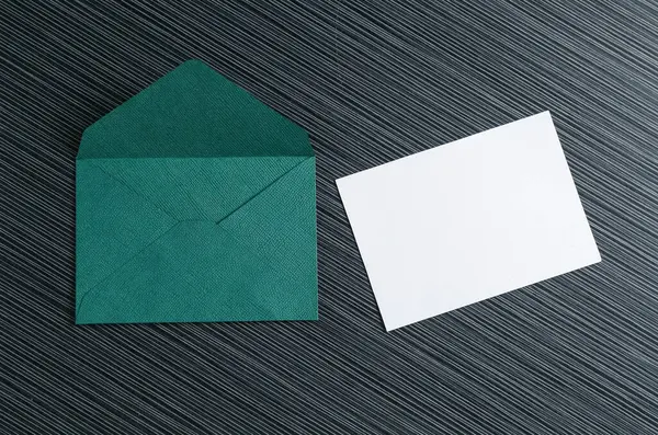 Boş davetiye kartı ve zarf siyah desenli masa üzerinde, düz yatıyordu. Tasarım için boşluk