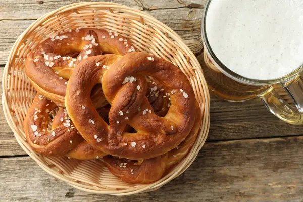 Sepette lezzetli krakerler ve ahşap masada bir bardak bira.