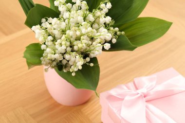 Vadi çiçeklerinin güzel zambakları ve hediye ahşap masada, yakın plan.