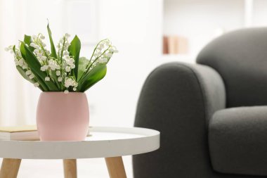 Kapalı alandaki sehpada duran bir buket güzel zambak. Metin için boşluk