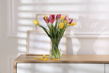 İçerideki ahşap masada güzel laleler ve çerçeveler.