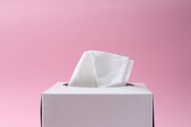 Pembe arka planda kağıt mendilli kutu, yakın plan. Metin için boşluk