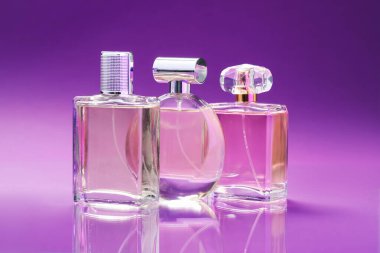 Renk eğimine karşı ayna yüzeyinde parfümlü şişeler, yakın plan