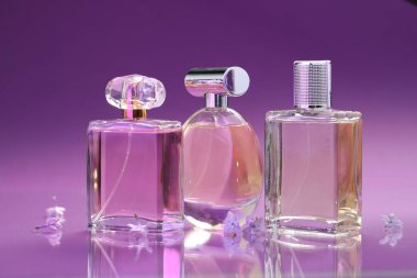 Parfümlü şişeler ve ayna yüzeyinde leylak çiçekleri renk değişimine karşı, yakın plan