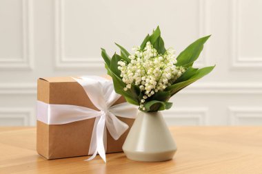 Vadi çiçeklerinin güzel zambakları ve ahşap masada hediyeler.