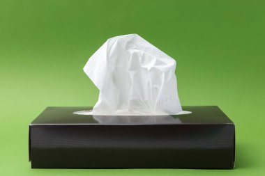 Yeşil arka planda kağıt mendilli kutu