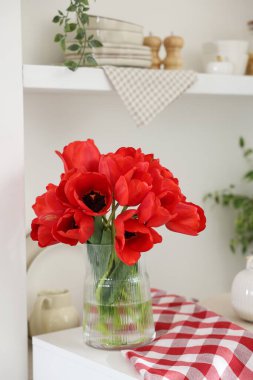 Dolabın içinde vazodaki güzel kırmızı laleler.