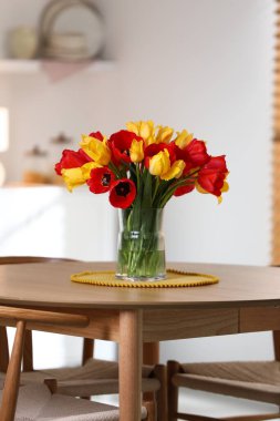 İçerideki ahşap masada vazodaki güzel laleler.