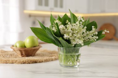 Mutfaktaki beyaz mermer masanın üzerinde güzel bir zambak buketi.