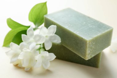 Bej arkaplanda sabun ve yasemin çiçekleri, yakın plan.