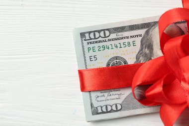Para bonusu. Beyaz ahşap masa üzerinde fiyonklu banknotlar, üst manzara. Metin için boşluk