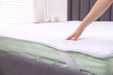 Yatakta yumuşak yatağa dokunan kadın, yakın plan.