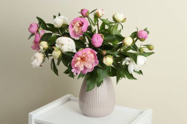 Vazodaki bir buket güzel şakayık çiçekleri raflarda bej arka planda