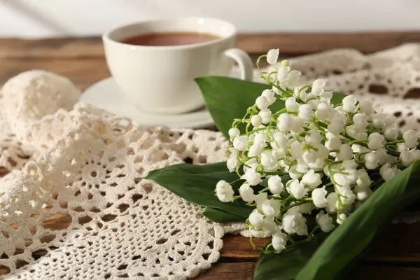 Vadi çiçeklerinin güzel zambakları ve ahşap masada çay, yakın plan.