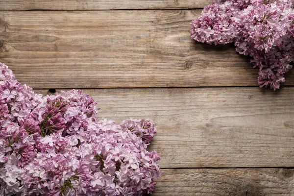 Ahşap masada güzel leylak çiçekleri, düz bir şekilde yatıyordu. Metin için boşluk