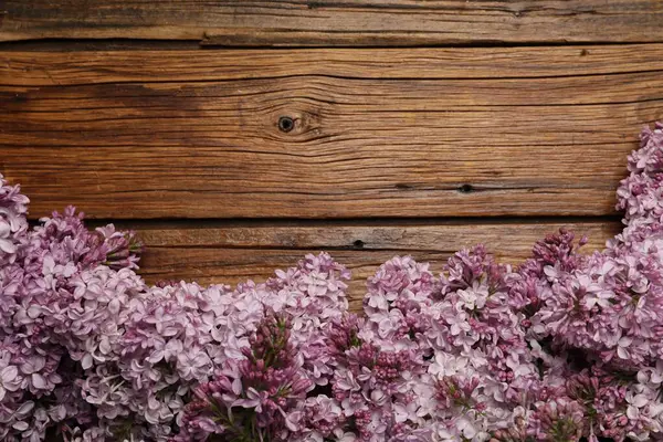 Ahşap masada güzel leylak çiçekleri, düz bir şekilde yatıyordu. Metin için boşluk
