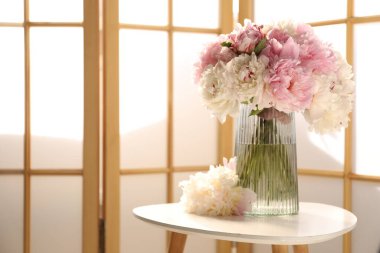 Beyaz masadaki vazodaki güzel şakayıklar, metin için yer.