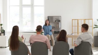 Akıl hocası ve grup insan içeride yaşam koçluğu dersinde toplantı yapıyorlar.