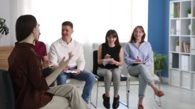 Yaşam koçluğu dersinde kapalı alanda toplantı yapan bir grup insan.