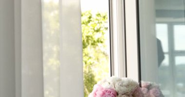 Pencere pervazındaki vazodaki güzel şakayıklar. Kamera aşağı iniyor
