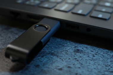 USB flaş bellek koyu gri masadaki dizüstü bilgisayara bağlandı.