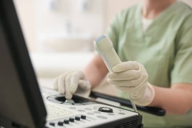 Klinikte ultrason makinesi olan profesyonel sonograf, yakın plan.