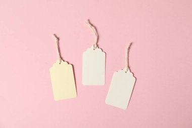 Pembe arka planda dizgileri olan boş etiketler, düz uzanma