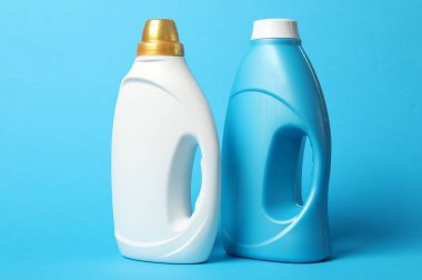 Açık mavi arkaplanda yumuşatıcı şişeler