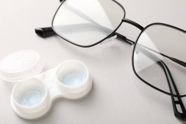 Beyaz arkaplanda kontak lensli ve gözlüklü dosya, yakın plan