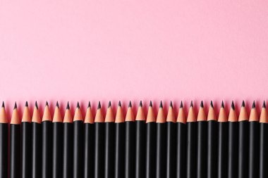 Pembe arka planda bir sürü keskin grafit kalem var. Metin için boşluk