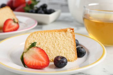 Böğürtlenli kek ve beyaz mermer masada çay, yakın plan.