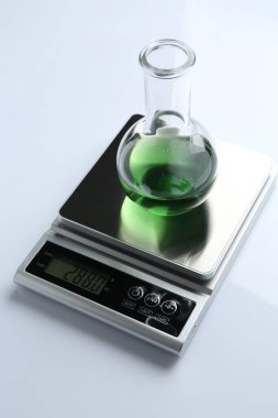 Beyaz arka planda numune matarası olan laboratuvar ölçeği