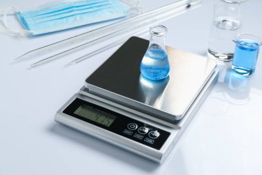 Beyaz arka planda örnek ve diğer laboratuvar ekipmanlarıyla ölçeklendir