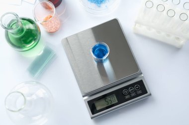 Beyaz arka planda deney tüpü ve diğer laboratuvar ekipmanlarıyla ölçeklendir