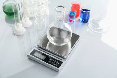 Beyaz ayna masasında boş şişe ve diğer laboratuvar camlarıyla ölçeklendir.