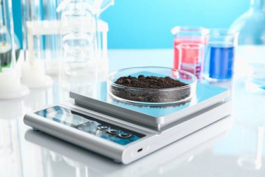 Beyaz ayna masasındaki Petri kabı ve diğer cam parçalarıyla açık mavi arkaplanı tart, kapat