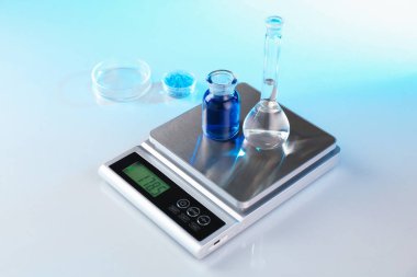 Örnekler ve laboratuvar camlarıyla beyaz masa üzerinde renk ışıklarıyla ölçeklendir, yakın plan