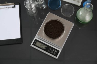 Siyah ayna masasında Petri kabı ve diğer laboratuvar camlarıyla ölçeklendir, düz uzan.