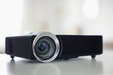 Beyaz masa üzerinde modern video projektörü, yakın plan.