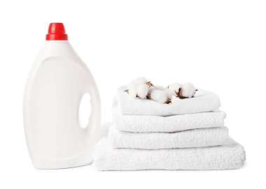 Bir şişe yumuşatıcı, yığılmış havlular ve beyaz üzerine izole edilmiş pamuk çiçekleri.