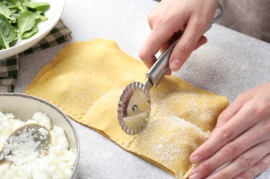 Işık masasında ravioli kesen kadın, yakın plan.