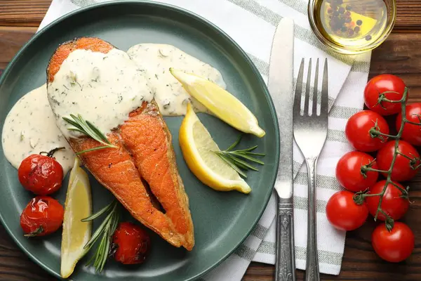 Deniz ürünleri. Sos, domates, biberiye ve limonla servis edilen lezzetli somon bifteği.