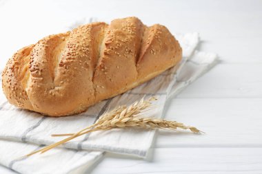 Taze ekmek somunu ve çiviler beyaz ahşap masada, yakın plan. Metin için boşluk