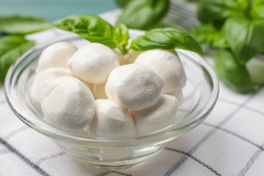 Mozzarella peynir topları ve fesleğen mavi masada, yakın plan.